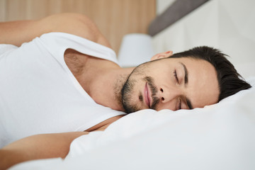 Fototapeta na wymiar Portrait of a handsome man sleeping in bed