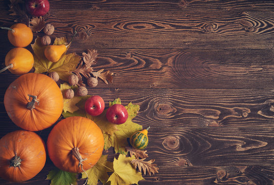 Autumn fruits and vegetables over wooden background, top view, flat lay, toned image