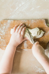 Fototapeta premium A child cuts the raw dough