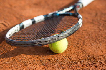 Close up view of tennis racket and balls on the clay tennis court, recreational sport
