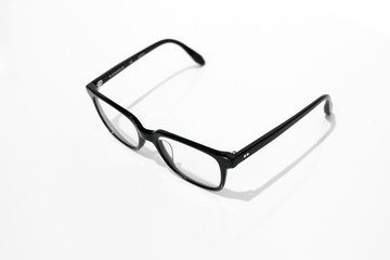 Black eyeglasses isolated on white background with shadow, retro / vintage / nerd / geek style