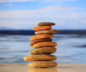 Zen stones stack on blue sky and sea background