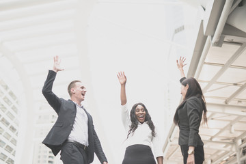 Cheerful business group people with arms raised in success successful concept