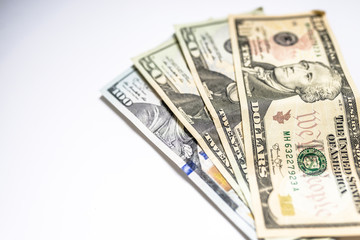 Pile of United States dollar hundred USD banknotes on white table. Selective focus