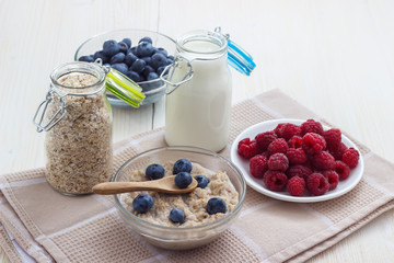 Breakfast healthy lifestyle of oatmeal with milk and berries raspberries and blueberries