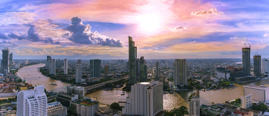 Fototapeta premium Panoramic cityscape of Bangkok in the evening viewing Taksin bridge crossing Chao Phraya River and skyscrapers along the river , Thailand