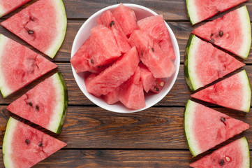 watermelon slices in plate on dark wooden background top view