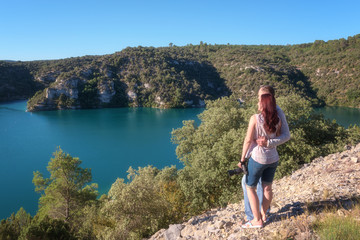 A couple of travelers enjoy the beautiful view of the lake Esparron (lac Esparron de Verdon), one of the five lakes of the Verdon Gorge National Park, Provence, Alpes-de-Haute-Provence, France