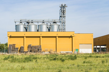 Fototapeta na wymiar External view of a typical factory Building with agricultural silos