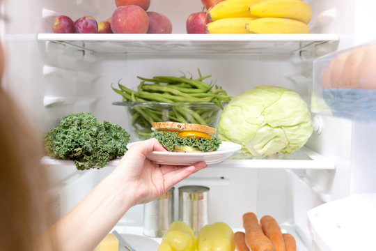 Woman taking a healthy sandwich out of the fridge