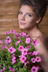 Beautiful young woman  holding a pot of ampel Petunia flowers