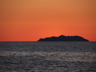 Beautiful sea sunset with island silhouette panorama . View of Gorgona island from Livorno city . Tuscany, Italy