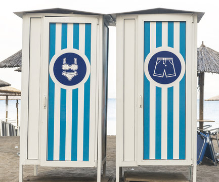 Image of male and female beach cabins in color of greek fla