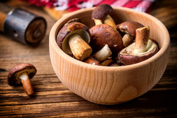 Forest mushroom in wooden bowl.