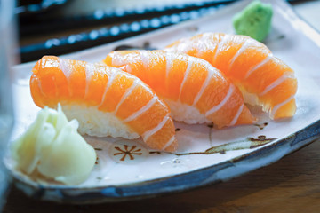 Salmon nigiri on plate with ginger, wasabi