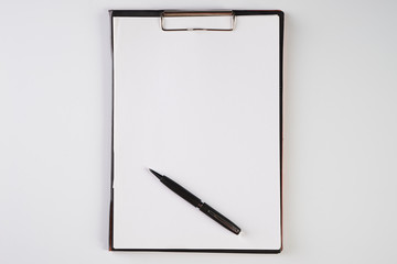 Clipboard with white sheet and black pen