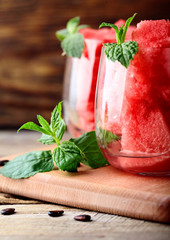 Watermelon. Watermelon cut into cubes in glasess decorated with mint on rustic wooden table.Watermelon seds.Copy space .Selective focus