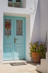 Entrance to a home. Traditional Greek architecture, blue front door with white washed walls taken on the island of Santorini, no people 