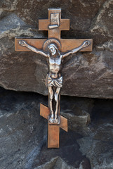 Silhouette of the crucified Jesus Christ on the cross the background of granite stones. The biblical prophet is the symbol of death. Mountain Calvary, Christmas, Easter background.