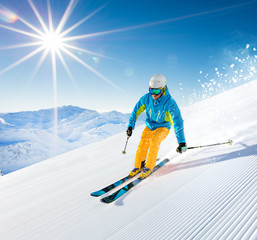 Skier skiing downhill in high mountains