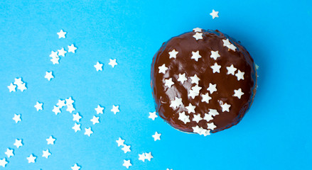 Decorated chocolate donut on blue background