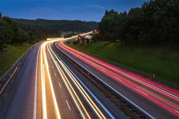 Fototapete Autobahn in der Nacht Beschleunigen Sie den Verkehr auf der Autobahn in der Abenddämmerung. Bunte Lichtspuren auf der Straße. Polen.