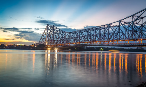 Historic Howrah bridge Kolkata at sunset with moody sky.