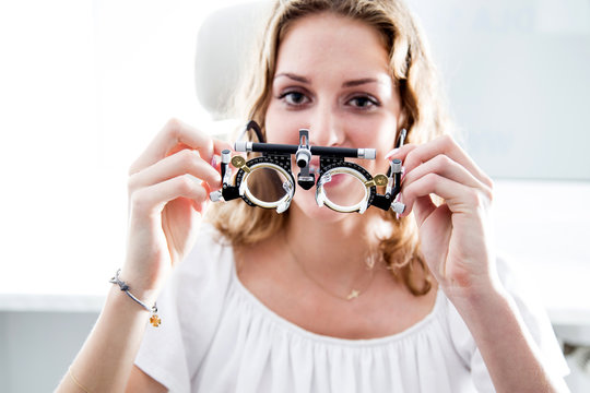 Młoda kobieta trzyma oprawki okulistyczne 