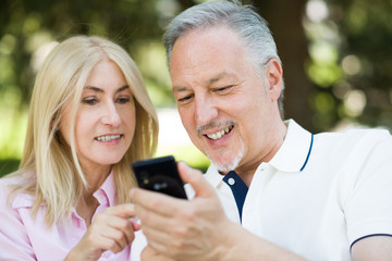 Happy mature couple using a cellphone