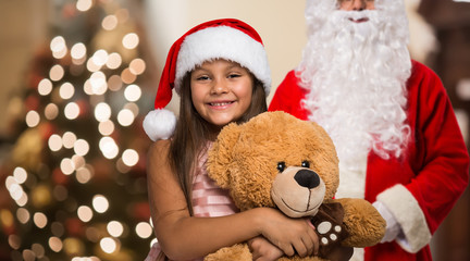 Fototapeta na wymiar Little girl holding a Christmas present in her house