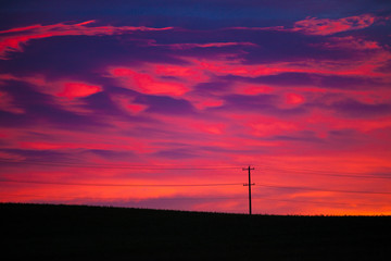 Fototapeta na wymiar Colorful sky at sunrise with telephone pole and line