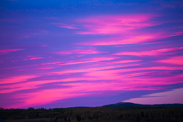 Fototapeta na wymiar Colorful sky at sunrise over a hilly landscape