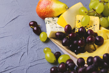 Cheese plate served with fresh grapes and pears