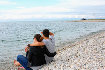Back view of a romantic couple at beach during summer vacation