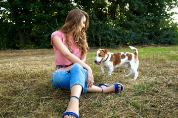 Cute girl is playing with her dog in the  park