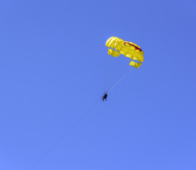 Tourists fly by parachute.