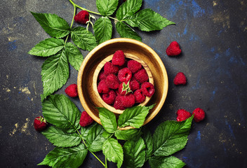 Fototapeta na wymiar Fresh raspberries and green leaves, top view