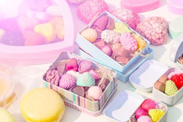 photo handmade soap in the form of sweets, heart, canteen, fruit, in boxes on the table close-up as background under the inscription