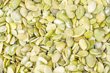 photo peeled pumpkin seed in bulk close-up under the background and the inscription