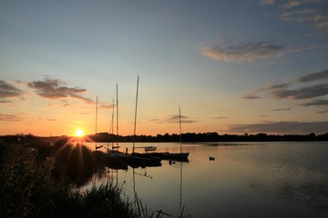 malerischer Sonnenuntergang am See mit Booten
