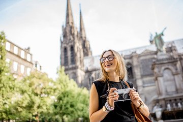 Portrait of a woman with photo camera traveling in front of the famous cathedral in...