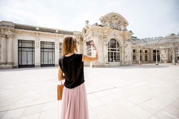 Woman photographing beautiful old Opera building in Vichy city in France