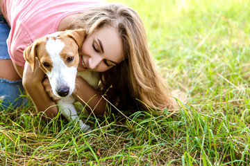 Cute girl is playing with her dog in the  park
