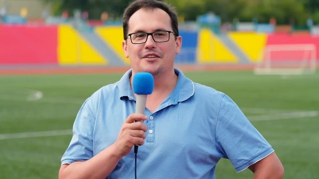 The journalist is reporting from the stadium for television