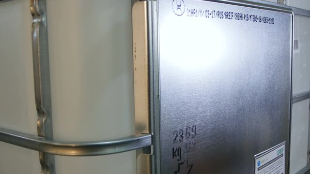 Closeup Worker Fixes Metal Label on Large Container