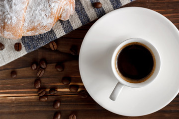 Fresh croissants and coffee on wooden table.
