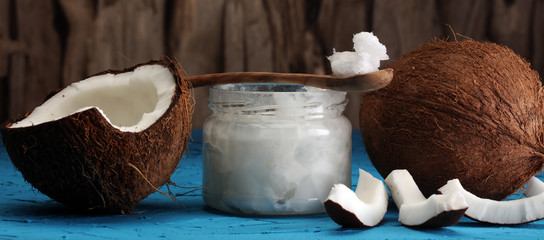 coconut oil and fresh coconuts on blue background