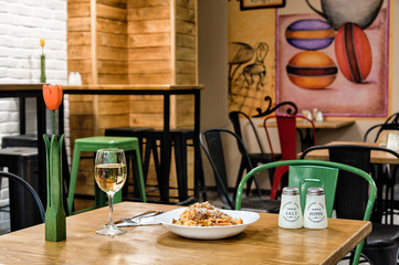  fresh pasta in plate with a glass of white wine
