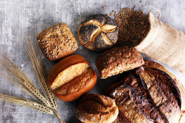 Different kinds of bread and bread rolls on board. Kitchen or bakery poster design.