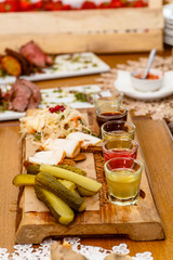 Traditional Russian snacks: cabbage, cucumbers and alcoholic drinks are on the table.